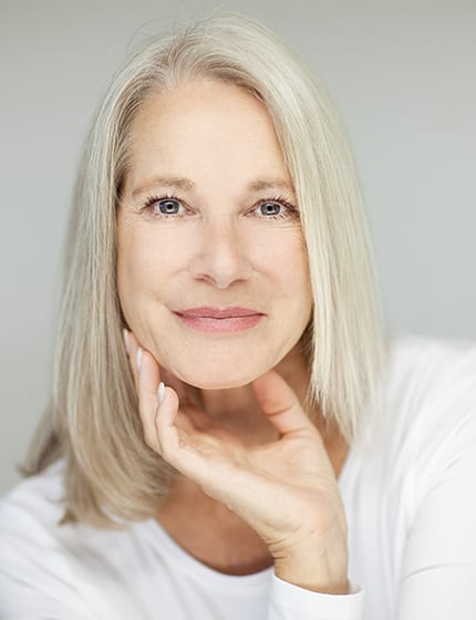 stunning beautiful and self confident best aged woman with grey hair smiling into camera, portrait with white background